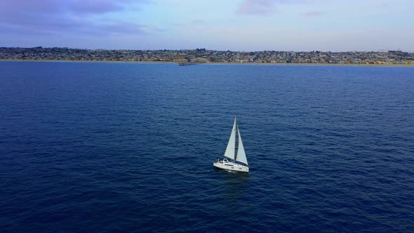 White Sailboat in beautiful blue water off the coast of Southern California aerial drone view.