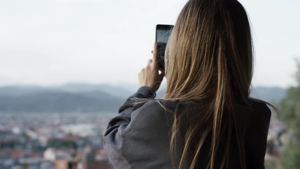 Woman Take a Photo Blurred City Hills Panorama on Background