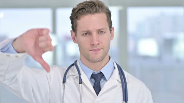 Portrait of Young Male Doctor Showing Thumbs Down in Office 