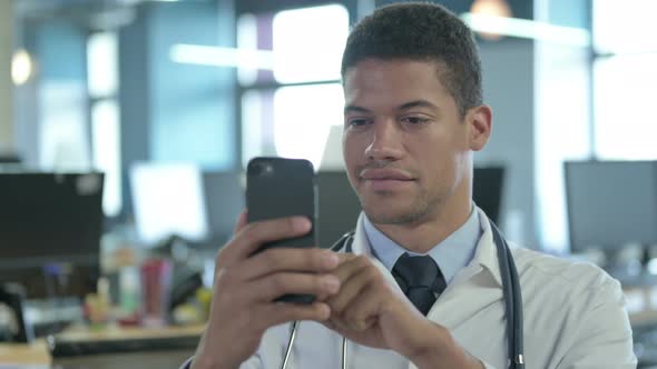 Portrait of African Doctor Using Smartphone and Smiling