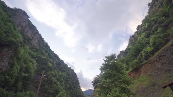 Time-lapse video of forested valley and sky.