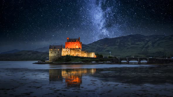 Milky way over illuminated Eilean Donan Castle at night, Scotland