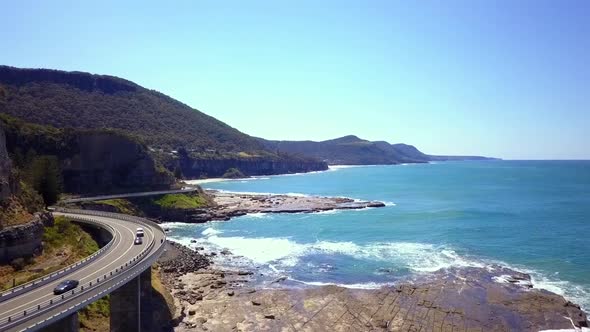 Aerial footage of a stunning long curvy Bridge next to the sea hightlights the Grand Pacific Drive w