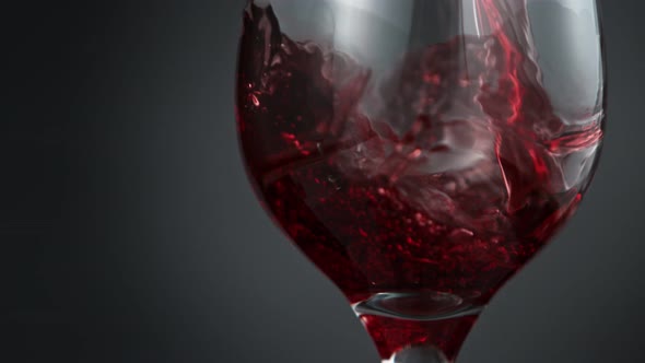 Pouring Red Wine in Super Slow Motion on Grey Background