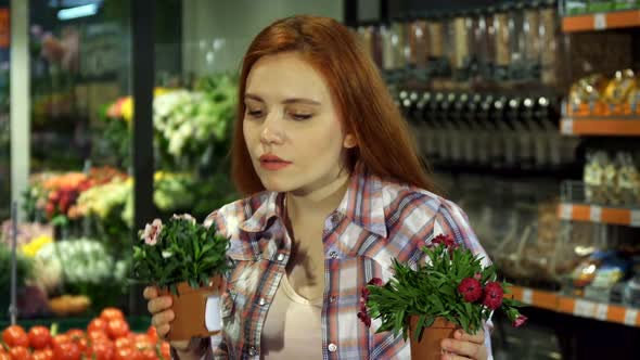 Woman Smells Different House Plants at the Supermarket