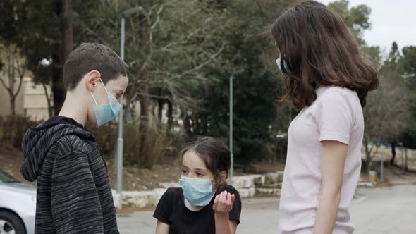 Coronavirus pandemic - kids walking outdoors with face masks to avoid corona