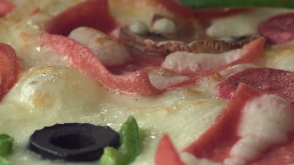 A pizza is cooking while it's rotating in the oven. Close up.