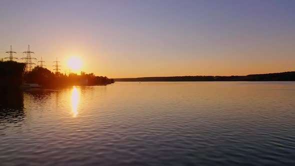 Evening river against the transmission lines at sunset. 