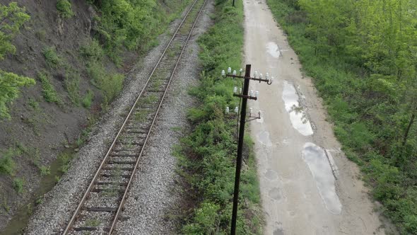 Flying over the railroad tracks and dirt road 4K drone video