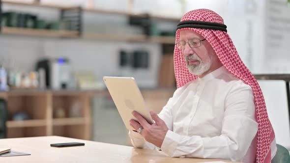 Professional Senior Old Arab Businessman Using Tablet in Caf� 