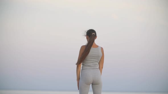 Girl Doing Exercise Against Sea Background