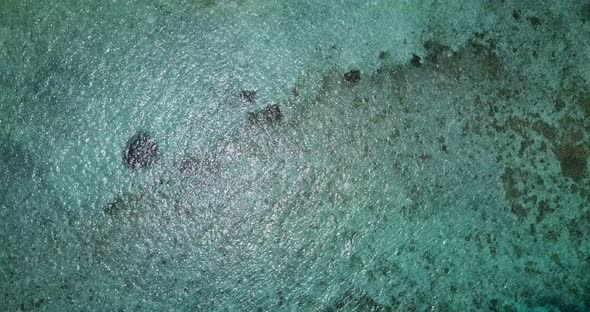 Wide fly over clean view of a white sand paradise beach and blue ocean background in high resolution