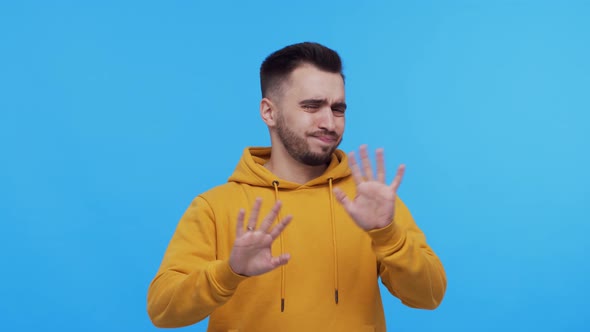 Expressive young man screaming and shouting over vibrant background.