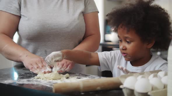 Little Black Girl with Her White Mother Making a Dough