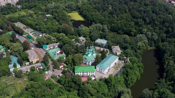 Nice top view of the church. Green domes among the trees. Monastery in the forest. alt