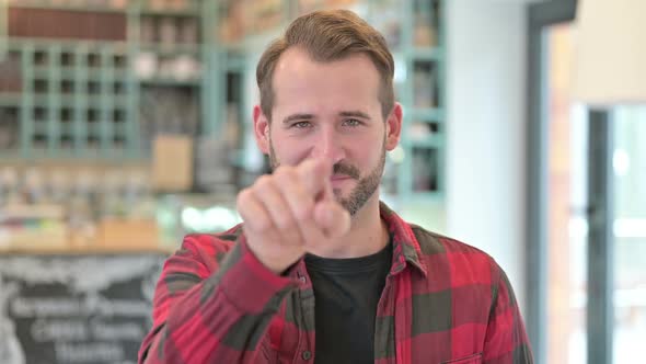 Portrait of Young Man Pointing at Camera and Inviting