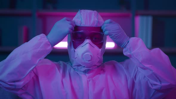 African Man Taking Off Hazmat Suit And Face Mask Indoors