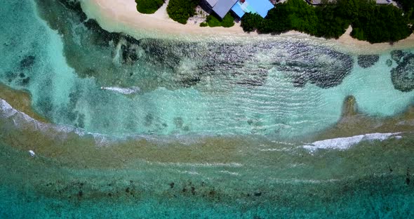 Wide birds eye clean view of a sandy white paradise beach and blue sea background in high resolution