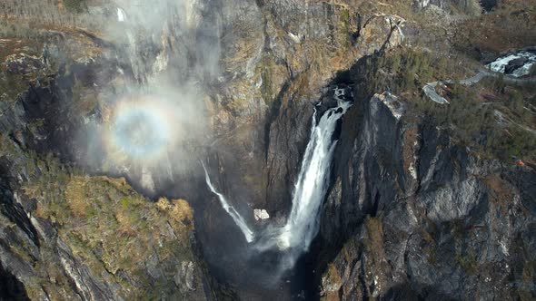 Aerial Overhead View Of Cascading Voringsfossen Waterfall In Norway With Rainbow Seen In Rising Mist