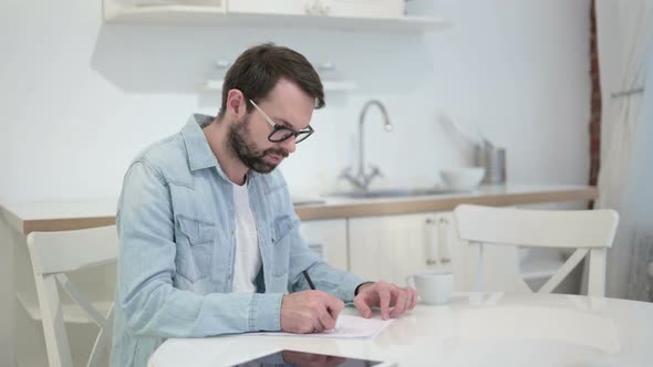 Focused Beard Young Man Reacting To Failure on Documents 