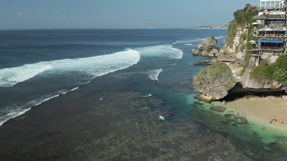 Aerial drone view of waves and surf off a small Balinese beach