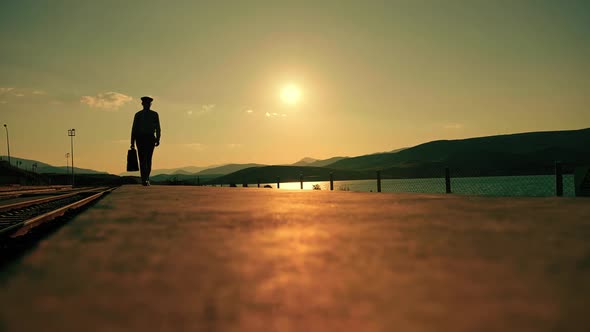Man Walking With Suitcase at Sunset