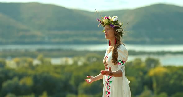 Portrait a Young Beautiful Woman in a Folk Costume and with a Floral Wreath on Her Head Sings Songs