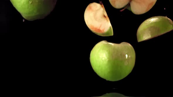 Super Slow Motion Pieces of Fresh Apple Fall Into the Water with Splashes