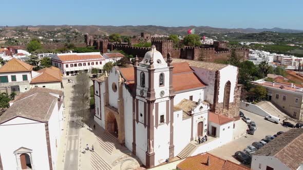 Silves Cathedral from the main portal overlooked by the Castle in the background in Algarve