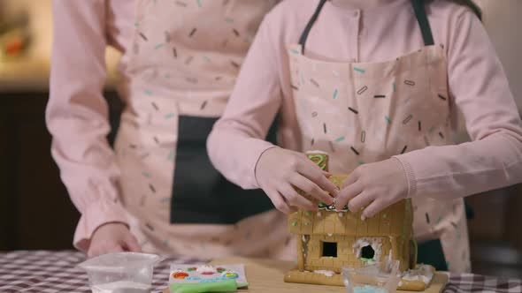 Live Camera Goes Down From Smiling Little Girl to Gingerbread House with Hands Placing Christmas