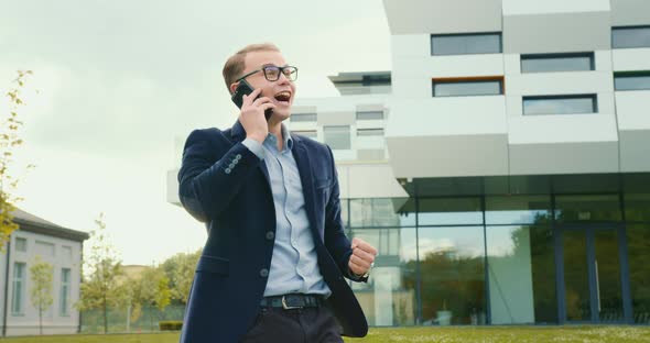 The Businessman Is Talking on the Phone and Is Very Happy