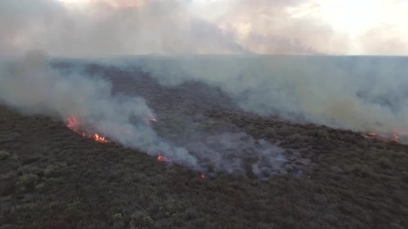 Aerial view of a small wildfire burning vegetation, Cambodia.