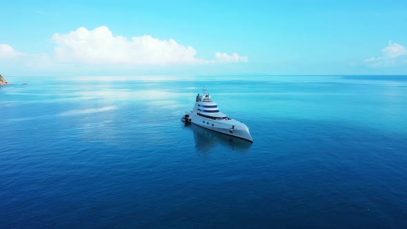 Megayacht designed by Phillipe Starck floating on calm blue lagoon near beautiful shoreline of tropi