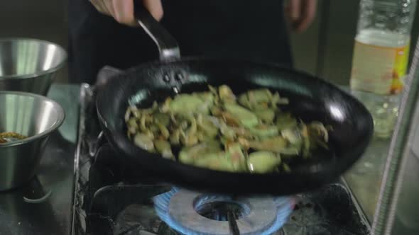 The Chef of the Restaurant Prepares Fried Vegetables in the Pan in the Kitchen Filtered Image