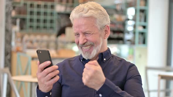 Old Man Celebrating on Smartphone