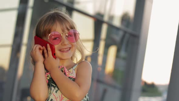 Tourist Kid Girl Wearing Trendy Sunglasses Use Phone. Child Using Smartphone for Call, Talk. Tourism