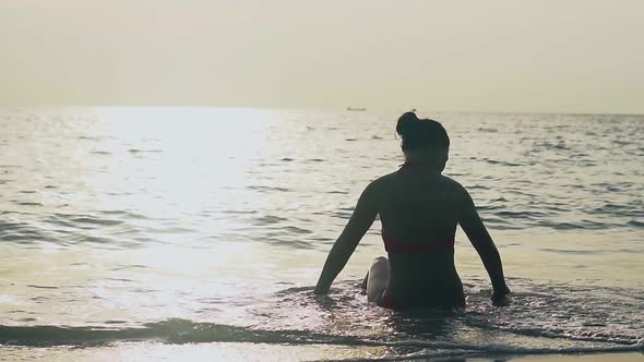 Silhouette of Slim Woman Sitting in Ocean Waves Slow Motion