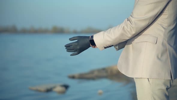 Man Puts On Protective Gloves Keeping Safety In Outdoor. Protection Epidemic Coronavirus Covid-19.