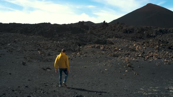 Man Traveler Walks Through the Lava Field Around Chinyero Volcano in the Teide National Park on the