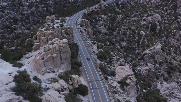 A car travels past rock hoodoos at dusk on the Catalina Highway Scenic Drive which leads to the top