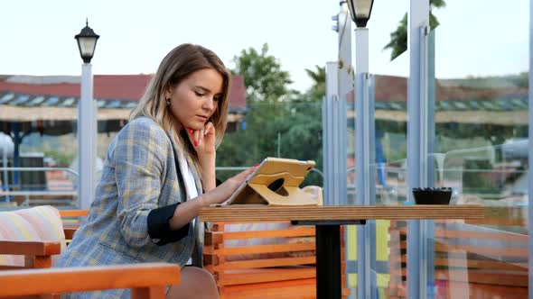 Charming Young Business Lady Sitting at the Table with Tablet