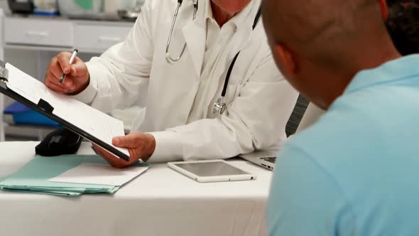 Male doctor discussing medical report with patient