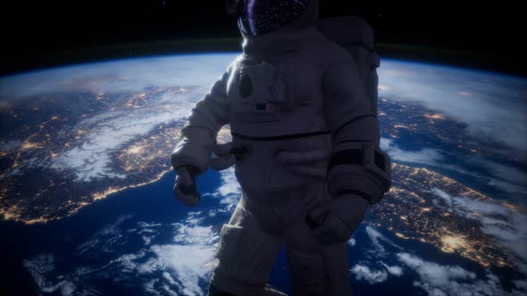 Astronaut in Outer Space Against the Backdrop of the Planet Earth alt