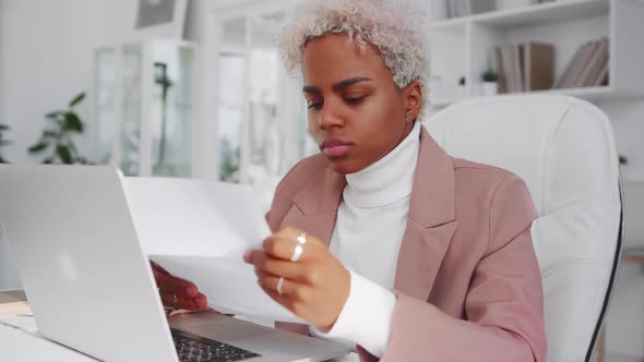 Successful African American Woman Reads Something From Sheet of Paper and Sighs