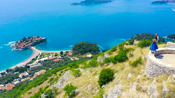 Young Couple Admire a Panorama of the Sea and Island of Sveti Stefan in Montenegro