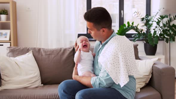 Middle Aged Father with Crying Baby at Home