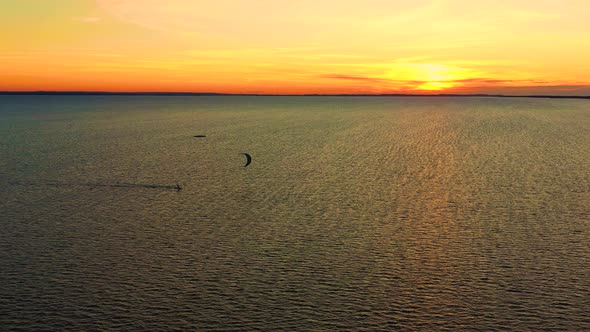 Aerial view. Kite surfing on the blue sea in the background of beautiful clouds. Sunset