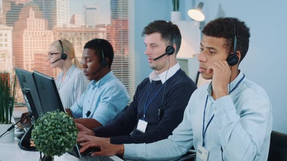 Medium Shot of Multiracial Call Center Agents Talking To the Clients in Headset