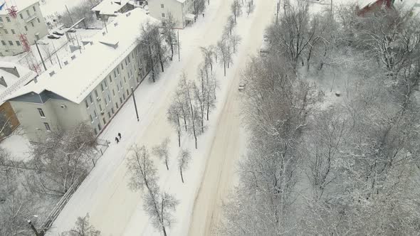 On a Snowcovered City Road After a Blizzard a Car is Driving