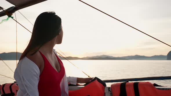 Woman Relaxing On Outrigger Boat Looking Away